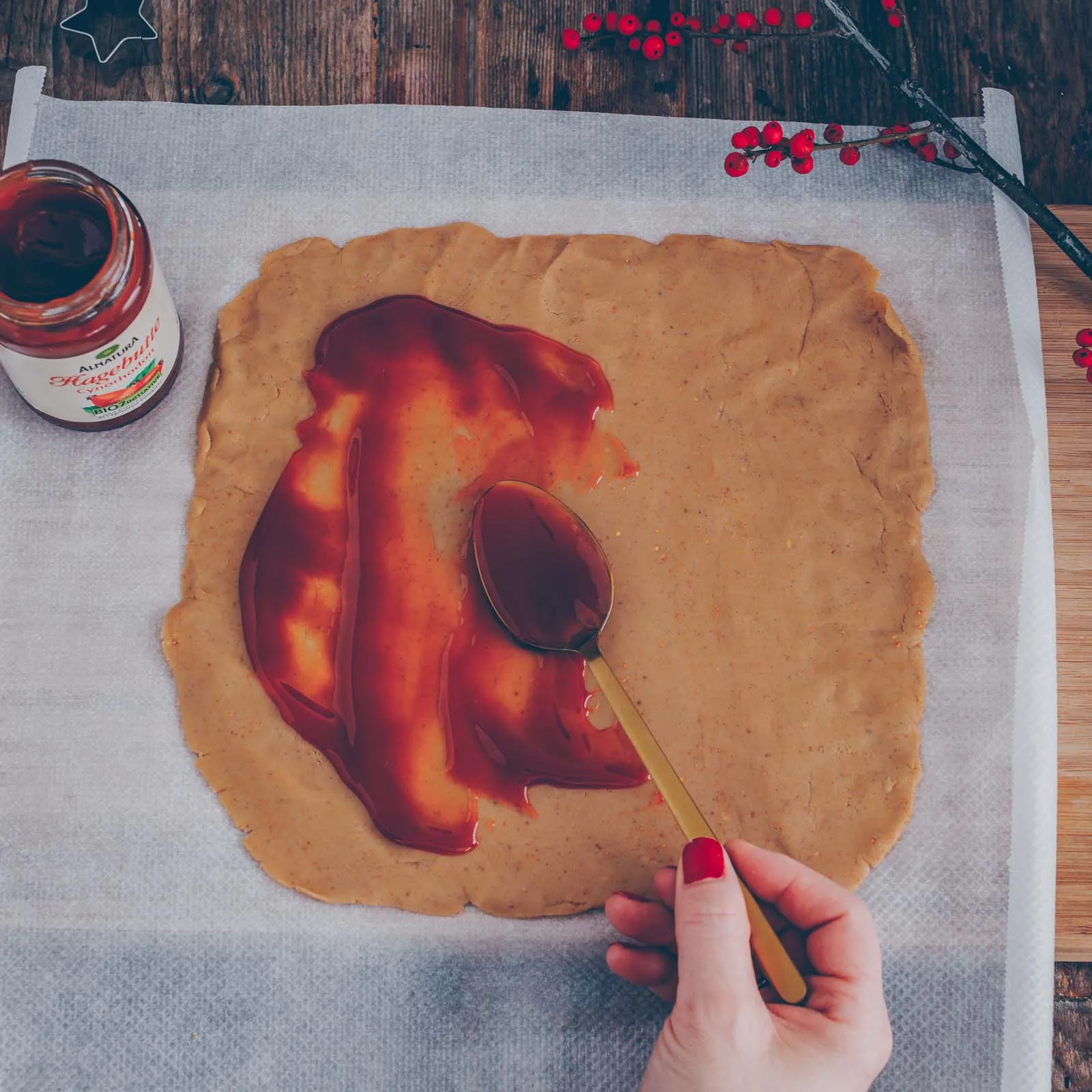 Frisch geschnittene, rohe Konfitüre-Rollen mit Hagebuttenfüllung, auf einem Backblech ausgelegt