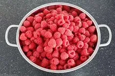 Frisch gewaschene Himbeeren in einer Schüssel, bereit für die Zubereitung von hausgemachter Himbeermarmelade.