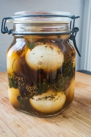 Frisch mit heißem Sud übergossene Soleier im Einweckglas ziehen lassen