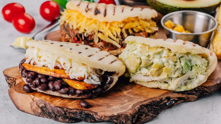 Frisch zubereitete Arepas, offen geschnitten und gefüllt, bereit zum Genießen.