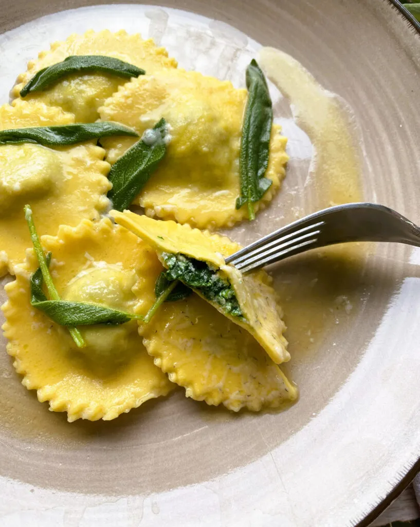 Frisch zubereitete Ravioli mit cremiger Spinat-Ricotta-Füllung auf einem Holzbrett