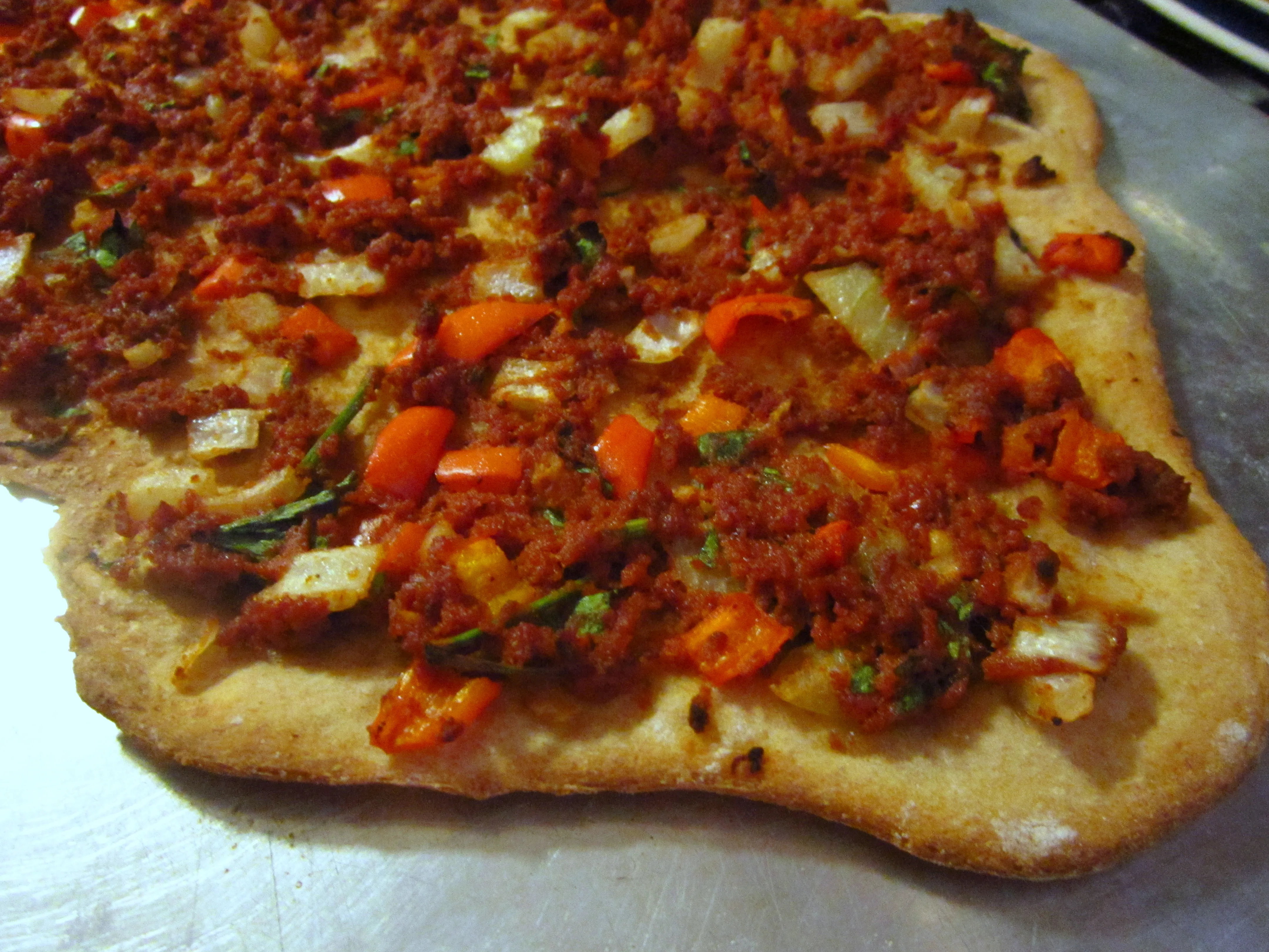 Frisch zubereitete türkische Pizza mit dünnem Teig und würziger Hackfleischfüllung