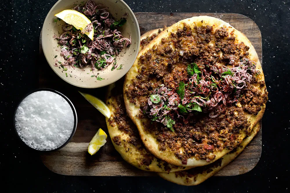 Frisch zubereitetes Lahmacun und ein Glas schaumiger Ayran, das perfekte türkische Duo