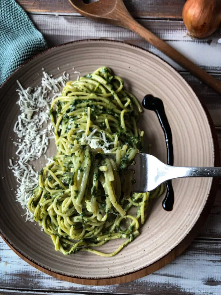 Frisch zubereitetes One Pot Spinat Pasta Rezept serviert mit frischem Pecorino und Balsamico