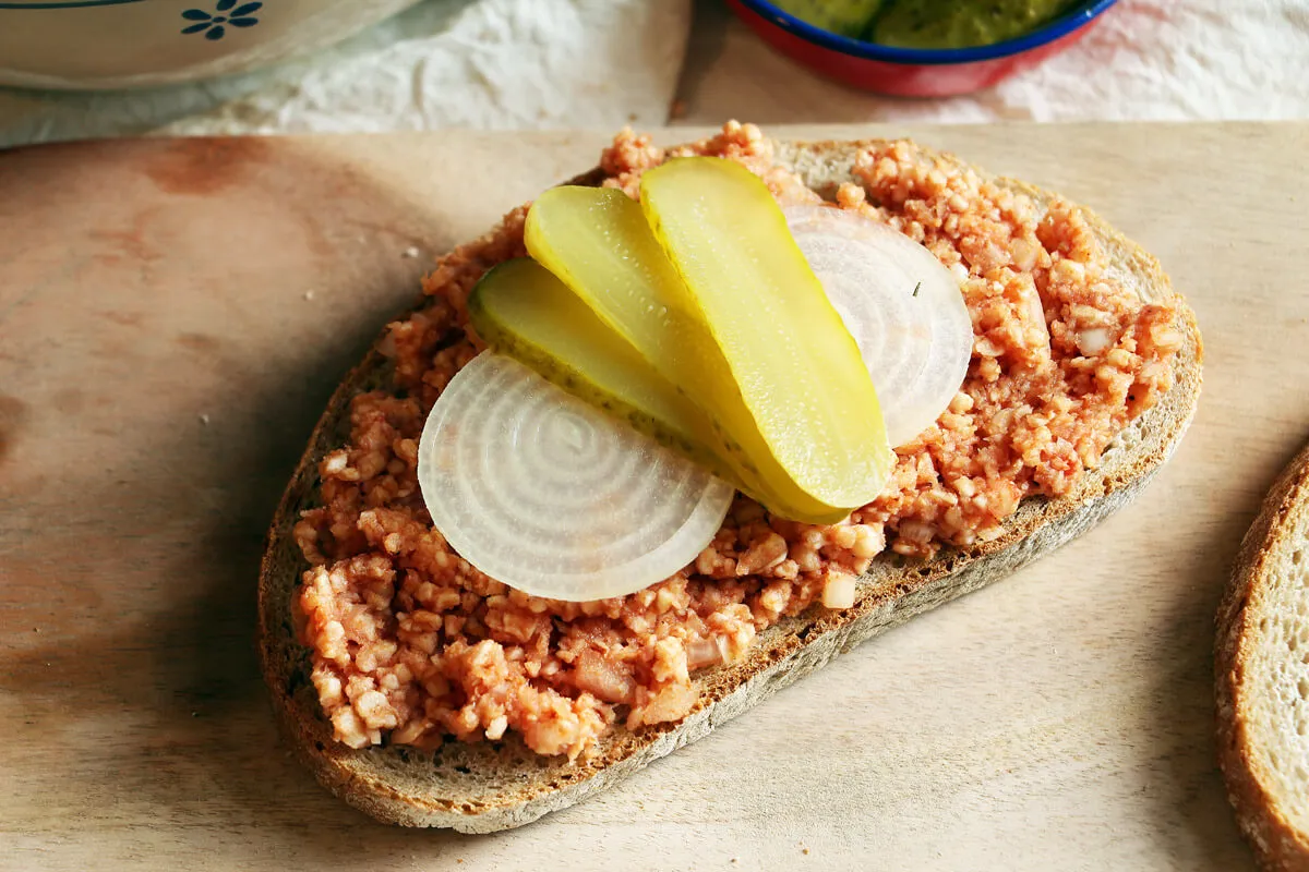 Frisch zubereitetes veganes Mett in einer Schale mit Zwiebelringen