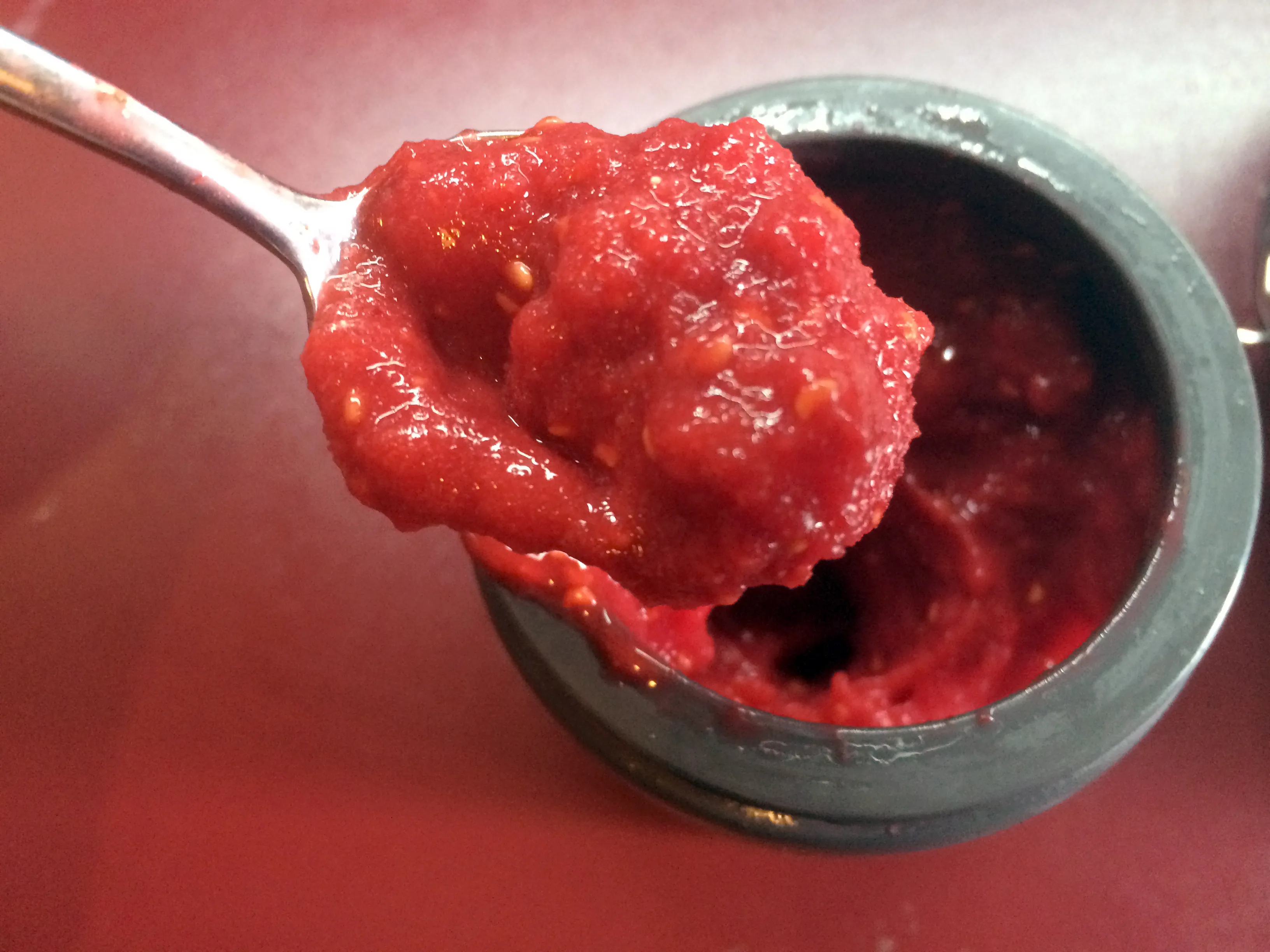 Frische Himbeeren werden für das Topping des zuckerfreien Kuchens püriert