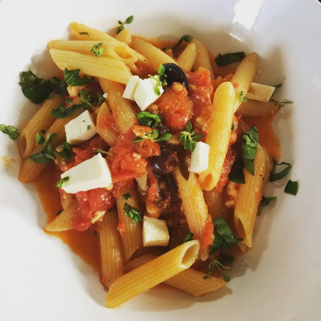 Frische Pasta mit schneller Tomatensauce, garniert mit Oliven und Feta, ein leichtes Mittagessen bei Hitze.