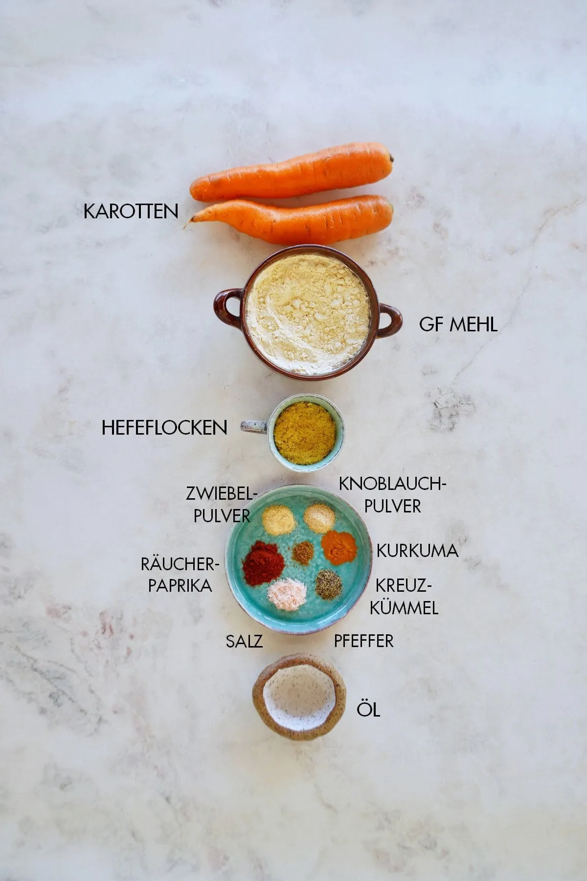 Frische Zutaten für Karotten-Bratlinge, darunter geraspelte Karotten, Mehl und Gewürze
