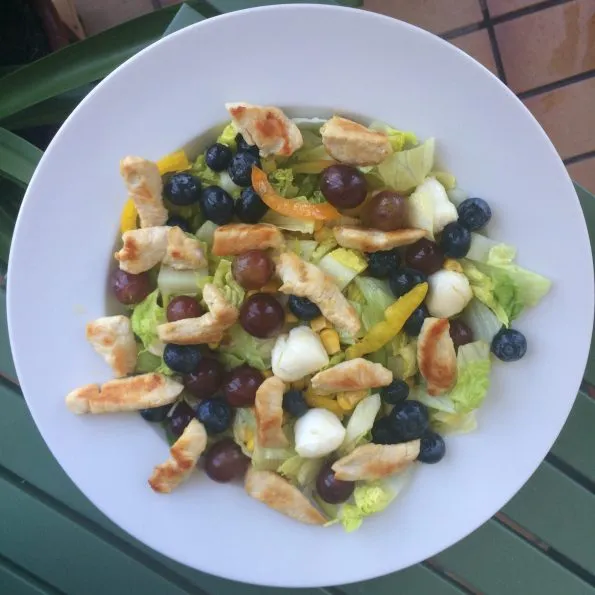 Frischer grüner Salat mit Putenbruststreifen, Mozzarella und frischen Erdbeeren, ideal als leichtes und proteinreiches Mittagessen