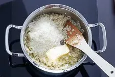 Frischer Parmesan und Butter werden in das fertige Risotto eingerührt