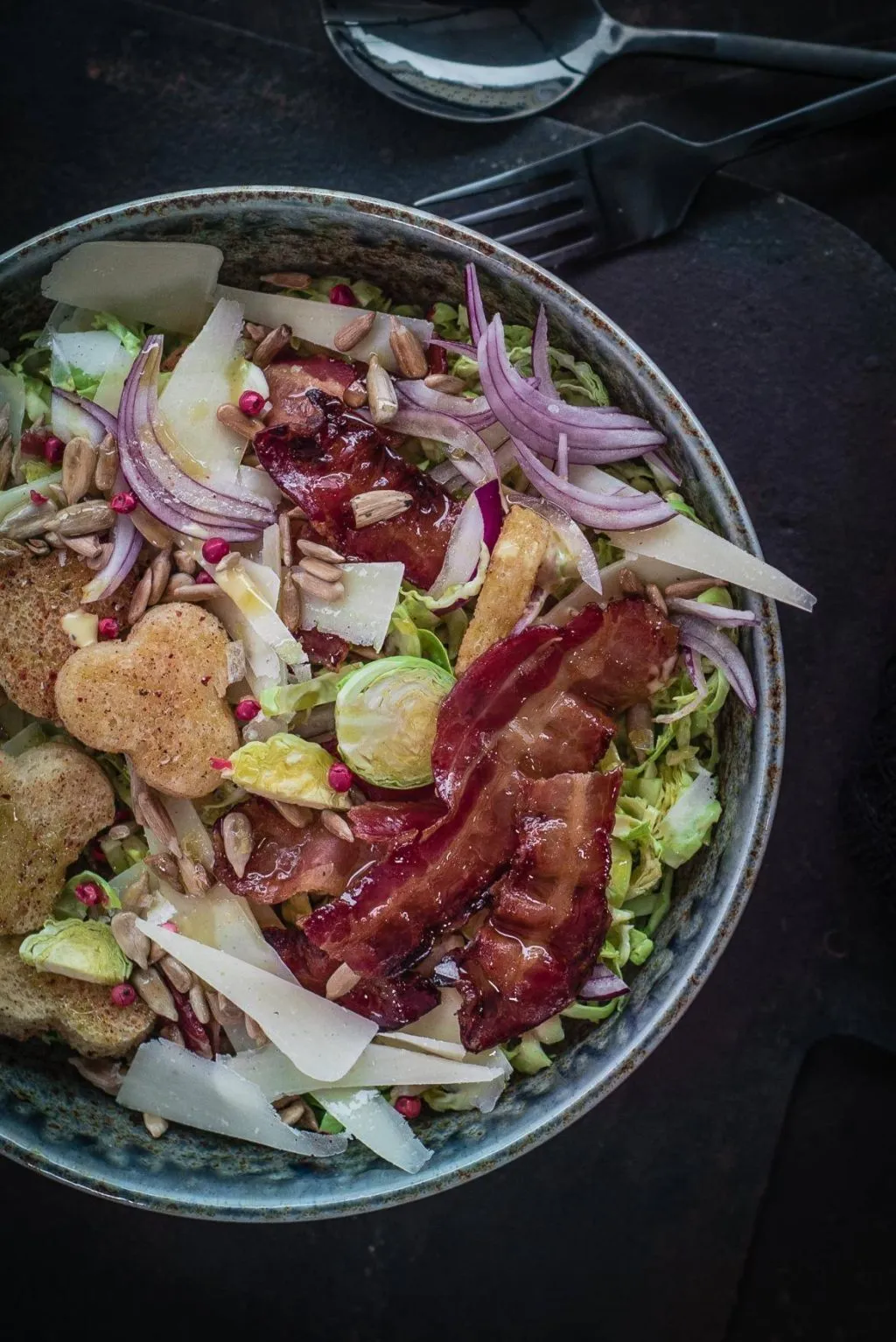 Frischer Rosenkohl Caesar Salad mit Parmesanstreifen und cremigem Dressing, appetitlich angerichtet