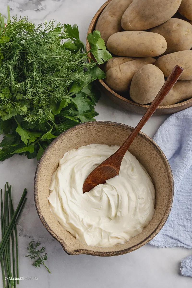 Frischer Sahnequark wird mit verschiedenen Kräutern zu cremigem Kräuterquark verrührt