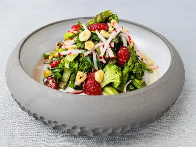 Frischer vegetarischer Gemüsesalat mit Brokkoli, Himbeeren und Radieschen als Oster-Vorspeise.