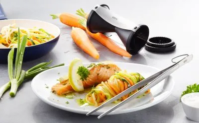 Frisches Lachsfilet mit bunten Gemüsespiralen und Zitronenbutter, angerichtet mit einem Spiralizer und Küchenpinzette