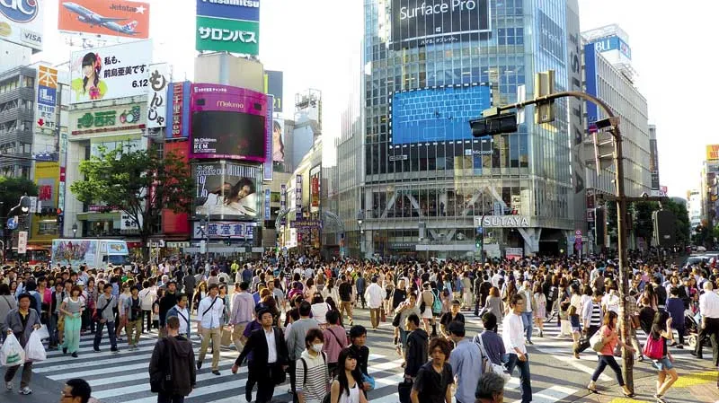 Futuristisches Stadtbild von Tokio, Japan, bei Nacht mit beleuchteten Wolkenkratzern und geschäftigen Straßen