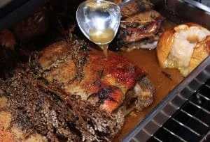 Gänsebrust wird im Bräter mit Flüssigkeit übergossen während des Schmorens