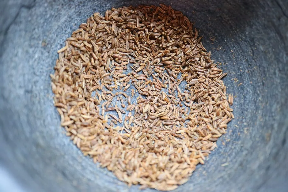 Ganzer Kümmel in einem Mörser, bereit zum Anstoßen für intensives Aroma im Rote Rüben Salat