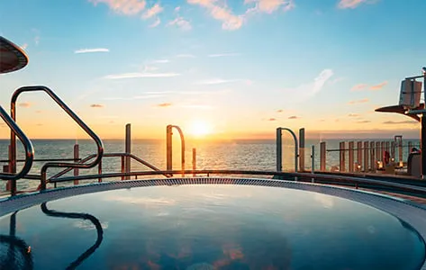 Gäste entspannen am Pooldeck der AIDAcosma unter der Sonne, ein Ort für Wellness und Erholung auf der AIDA Reise