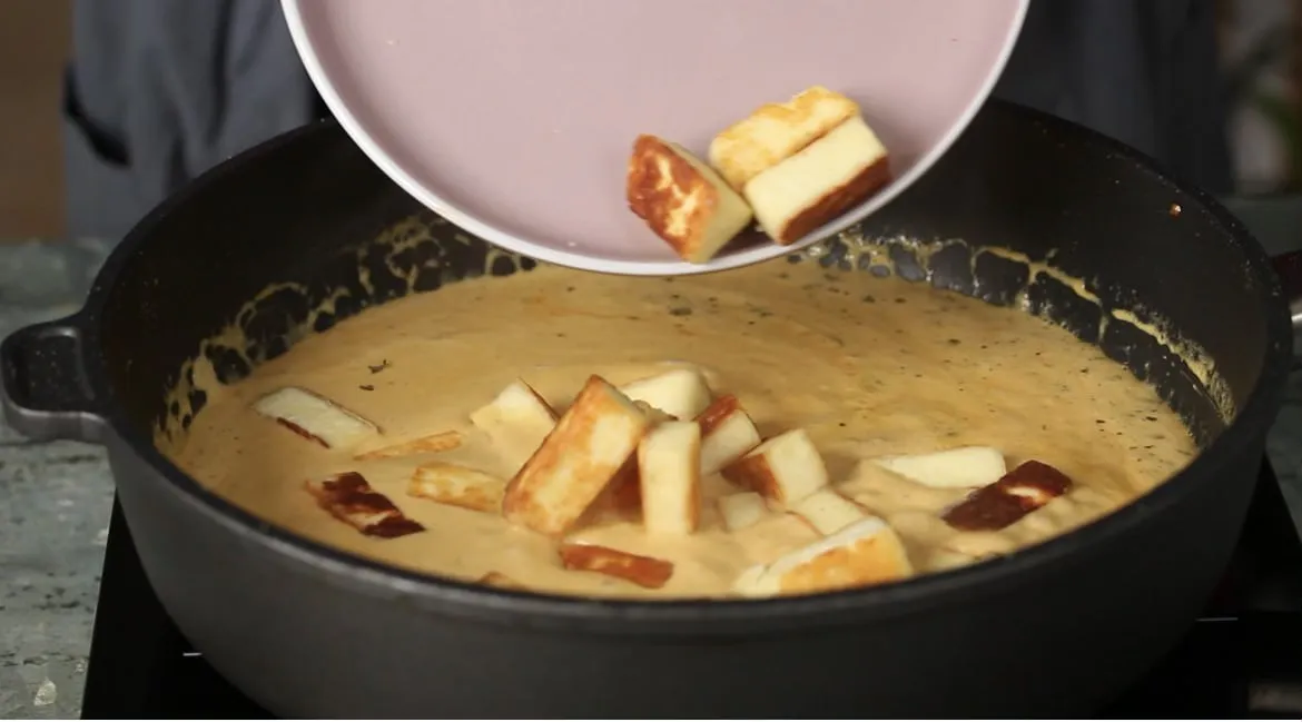 Gebratener Paneer wird in die Currysauce gegeben