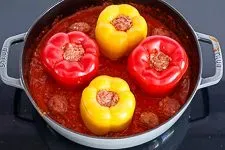 Gefüllte Paprikaschoten und Hackbällchen schmoren in der mediterranen Tomatensoße im Ofen