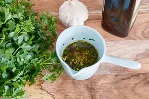 Gehackte Petersilie und Knoblauch werden mit Olivenöl, Meersalz und Pfeffer zu einem aromatischen Spargel-Dressing vermengt