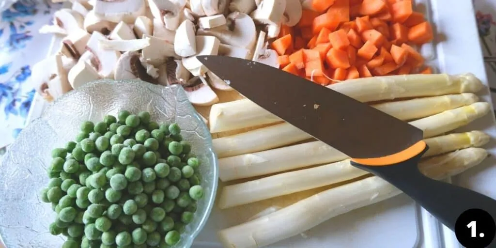 Gehacktes Gemüse wie Karotten, Champignons, Spargel und Erbsen, bereit für die Zubereitung von Hühnerfrikassee