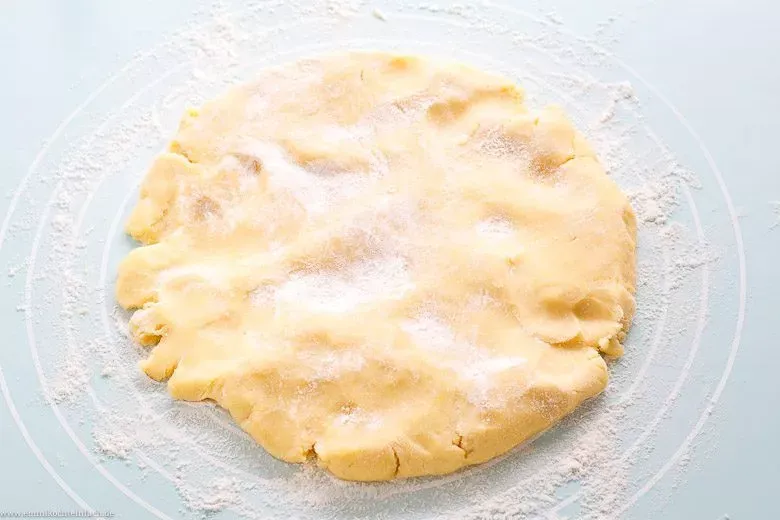 Gekühlten Quiche Teig mit Nudelholz ausrollen, bereit für die Backform.