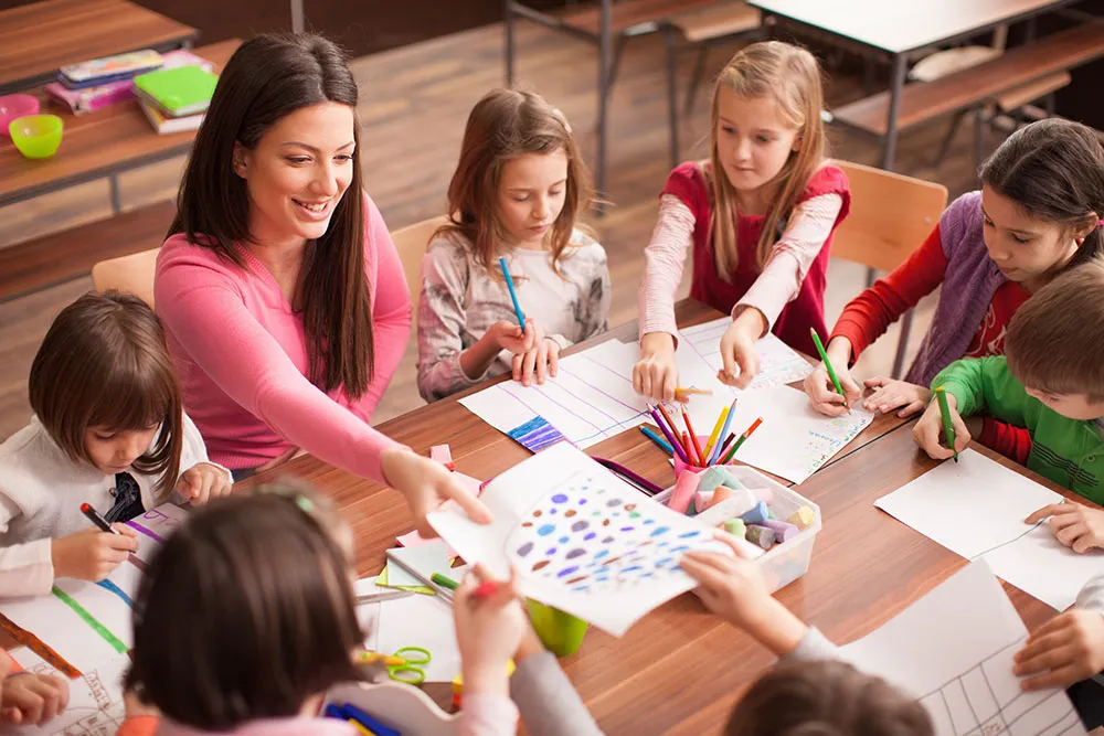 Gemeinsames Lernen: Pädagogin und Kinder beim kreativen Gestalten