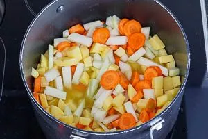 Gemüse für das Kohlrabi Hauptgericht in Gemüsebrühe im Topf köcheln lassen