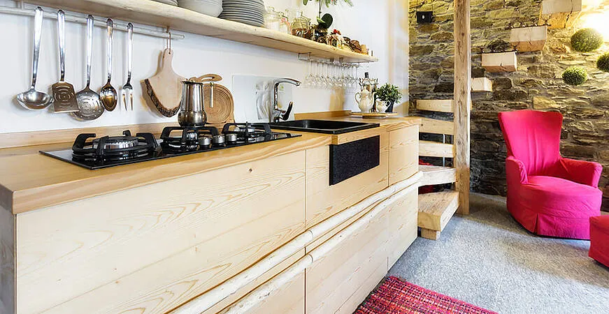 Gemütliche Vollholzküche in einem Ferienhaus, die eine warme und einladende Atmosphäre schafft