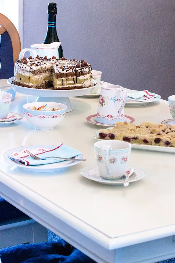 Gemütlicher Kaffeetisch mit Apfel-Nuss-Sahne-Torte und Geschirr im Greengate-Stil