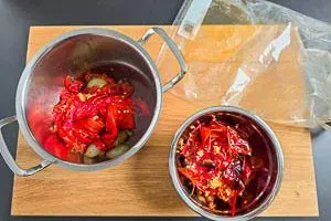 Geschälte Paprika, Tomaten, Zwiebeln und Knoblauch in einem Topf, bereit zum Pürieren für das Ajvar Rezept