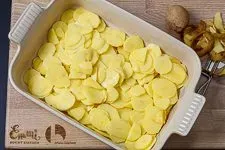 Geschälte und in dünne Scheiben geschnittene Kartoffeln in der Auflaufform