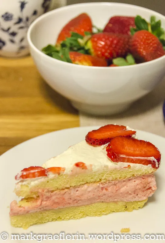 Geschichtete Erdbeer-Sahnetorte vor dem Dekorieren, mit sichtbarer Erdbeercremefüllung.