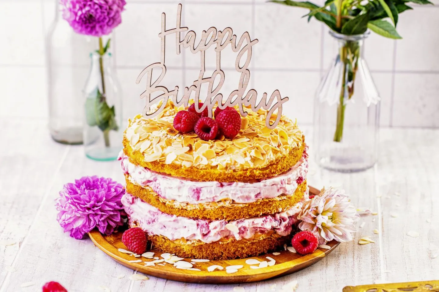Geschichteter Himbeer-Quark Naked Cake von der Seite, mit Himbeeren dekoriert