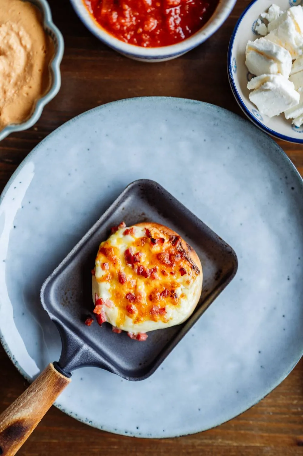 Geschmolzener Raclette-Käse in einem Pfännchen mit frischem Brot
