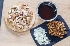 Geschnittene Champignons und Zwiebeln in Schüsseln, bereit für die Zubereitung.