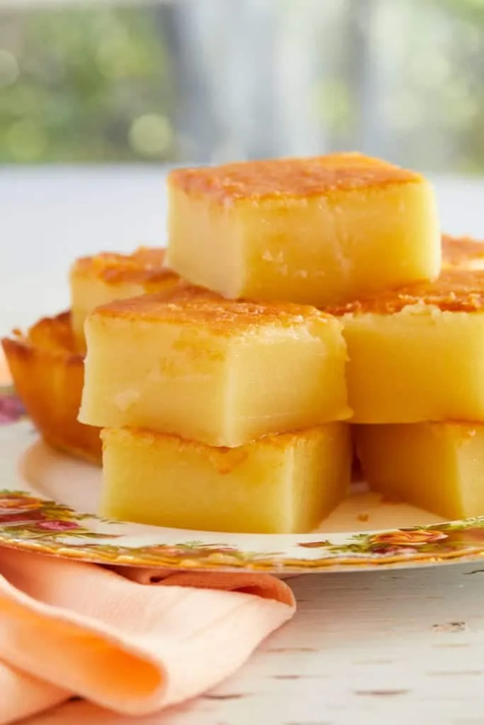 Gestapelte Stücke von Hawaiian Butter Mochi auf einem Teller, bereit zum Servieren.