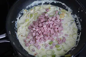 Gewürfelten Kochschinken unter die köchelnde Sahnesoße rühren
