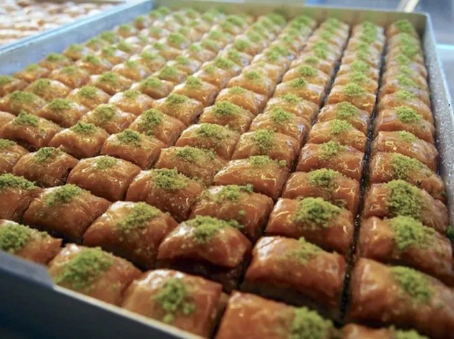 Glänzende Baklava-Stücke mit Pistazien in Honigsirup, kunstvoll arrangiert bei Güzel Bäckerei