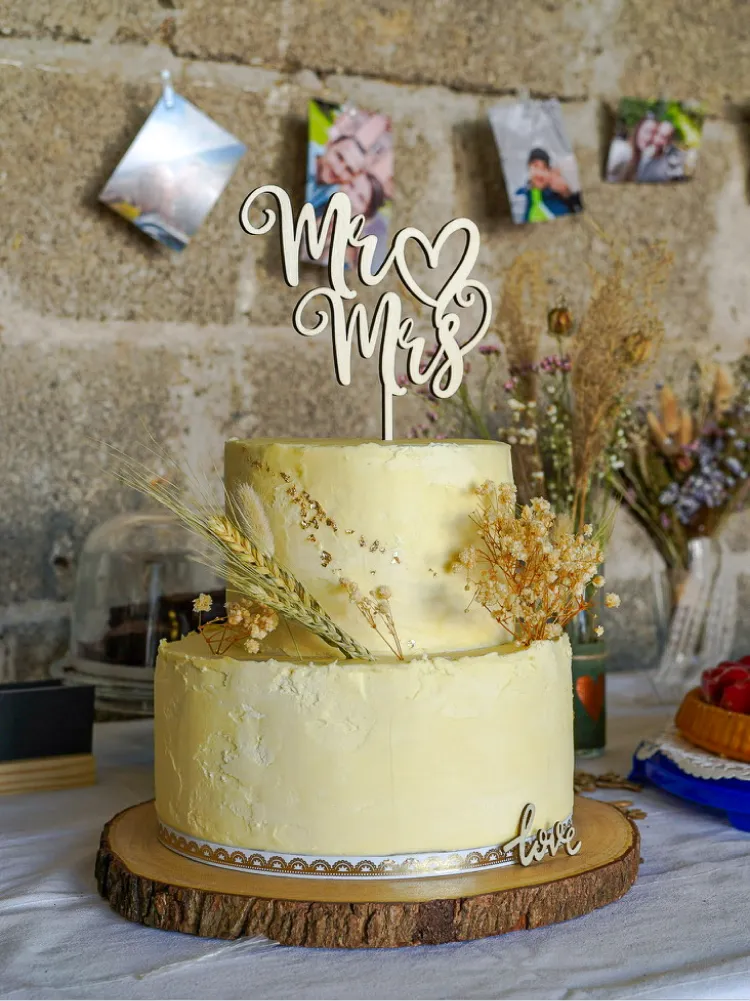 Glückliche Bäckerin mit ihrer ersten selbstgebackenen Hochzeitstorte für eine Boho-Vintage-Hochzeit