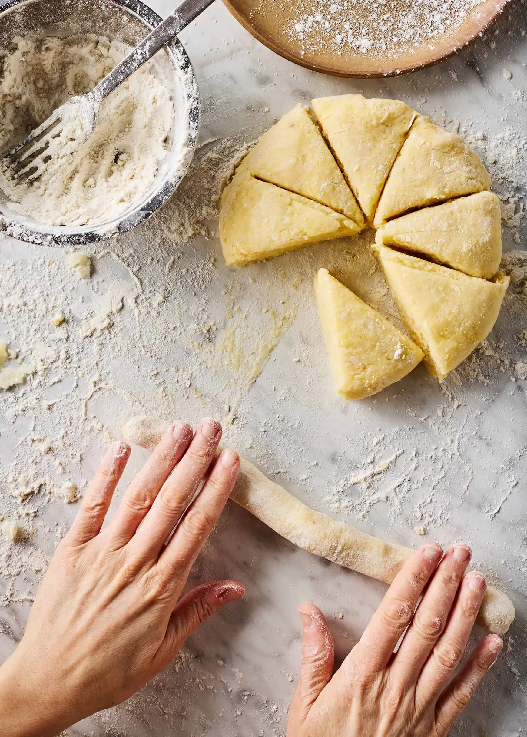 Gnocchi-Teig wird von Hand zu einer langen Rolle geformt, bereit zum Schneiden.