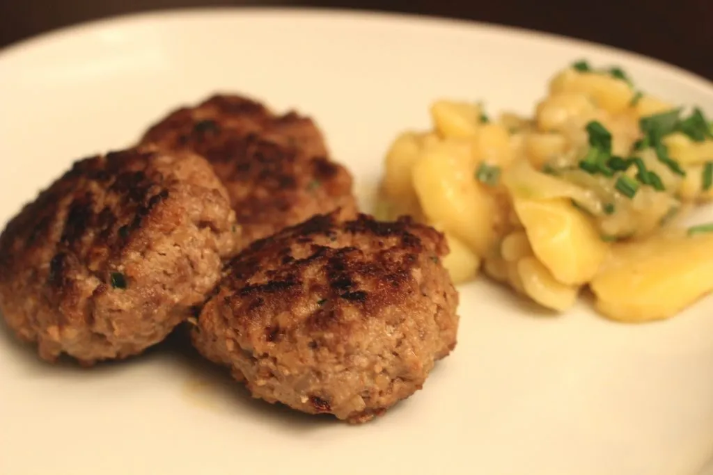 Goldbraun gebratene Frikadellen, Buletten oder Fleischpflanzerl mit Kartoffelsalat