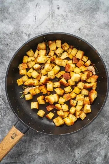 Goldbraun geröstete Ciabatta-Würfel in der Pfanne – perfekt für Panzanella essen und trinken