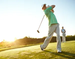 Golfer schlägt Ball ab mit Konzentration und Entschlossenheit auf dem Fairway.