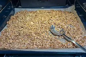 Granola wird im vorgeheizten Ofen gebacken, um eine goldbraune und knusprige Textur zu entwickeln.