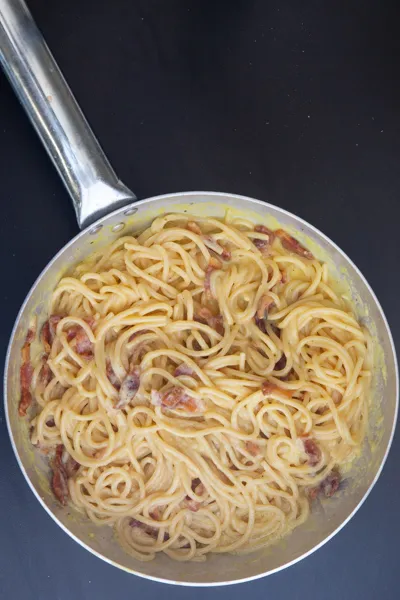 Guanciale wird zu den Spaghetti hinzugefügt