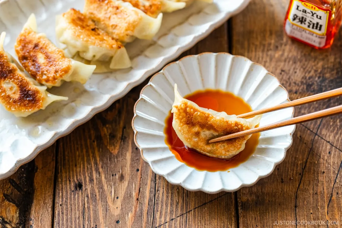 Gyoza in Dip-Sauce aus Sojasauce, Essig und japanischem Chiliöl.