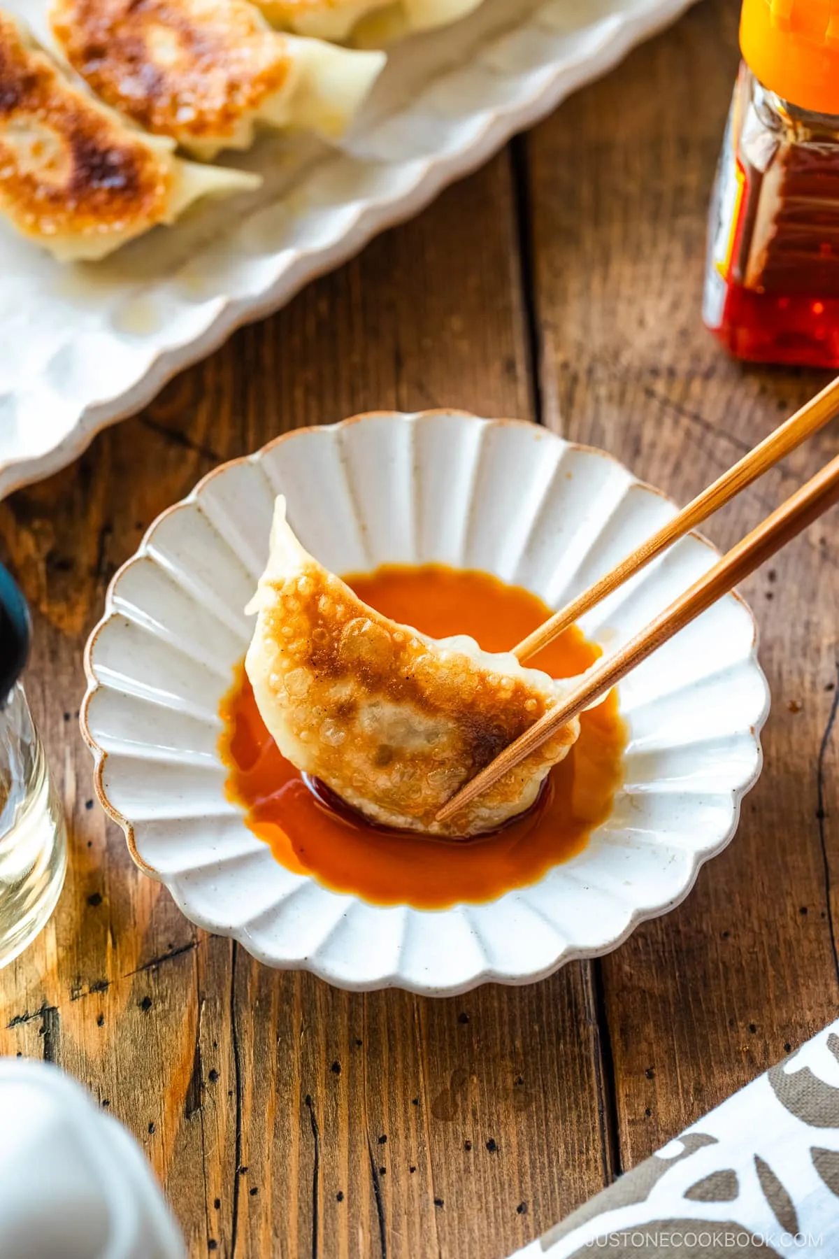 Gyoza in einer Schüssel mit Dip-Sauce aus Sojasauce, Essig und japanischem Chiliöl.