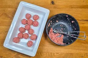 Hackbällchen formen: Gemischtes Hackfleisch wird mit einem Eisportionierer zu gleichmäßigen Bällchen verarbeitet